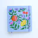 Notebook with floral and fruit design on a light blue background