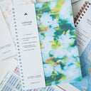 A lightweight spiral-bound planner with weekly and monthly layout, frosted softcover, and notebook style